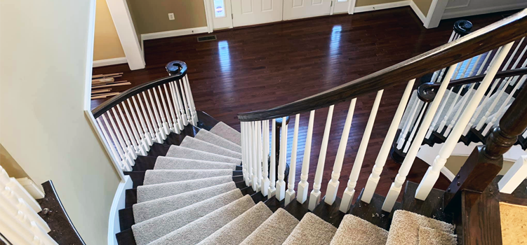 dark red hardwood oak floors install with customer railing and carpeted steps in Baltimore